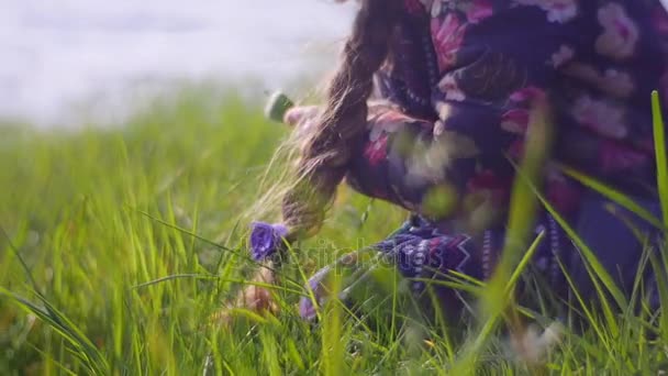 Pelirroja chica está sentado en suave verde hierba — Vídeos de Stock