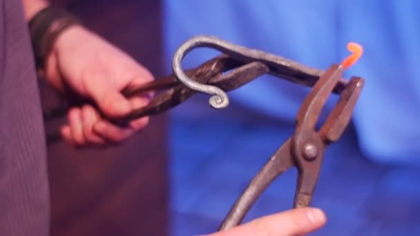 Un hombre crea ganchos de metal — Vídeo de stock