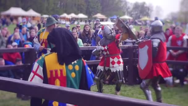 Historische re-enactment van een ridder toernooi Opole-slag met zware zwaarden kleine Knight Camp van middeleeuwse Warriors menigte van kijkers kijken achter het hek — Stockvideo