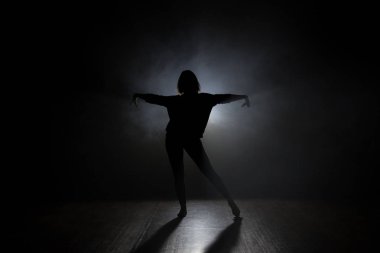 Studio smooke karanlık bir arka plan ile dansçı
