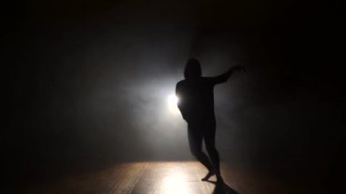 Kadın dansçı arkadan aydınlatmalı, duman.