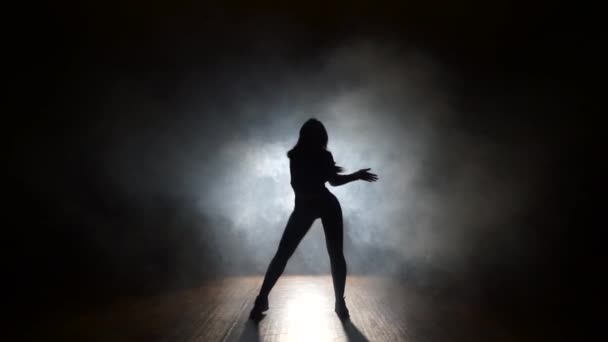 Sexy bailarina en un humo sobre un fondo negro — Vídeos de Stock