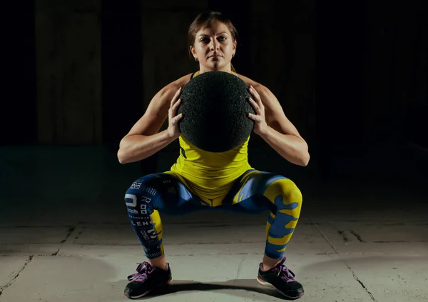 Chica sentadillas con la pelota en el gimnasio — Foto de Stock