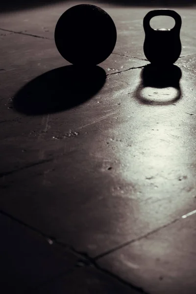 Kettlebell e bola backlight e sombra no ginásio — Fotografia de Stock