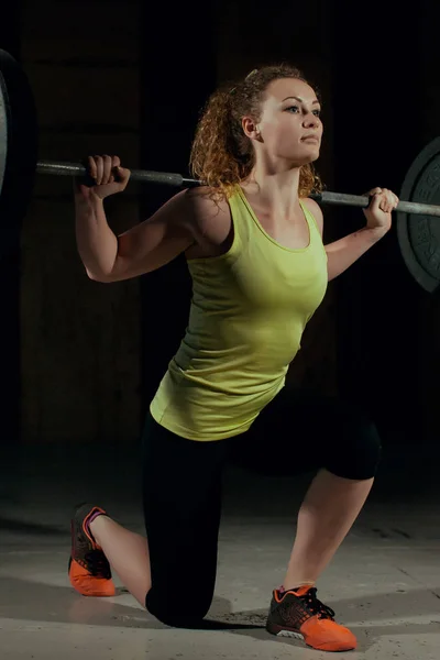 Mulher desportiva exercitando com barbell no ginásio — Fotografia de Stock