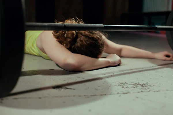 Mujer joven estirando la espalda después de pesadas ejercicios de barra en un gimnasio —  Fotos de Stock