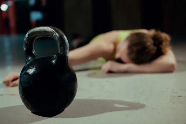 Mujer joven estirando la espalda después de entrenamiento pesado kettlebell en un gimnasio —  Fotos de Stock