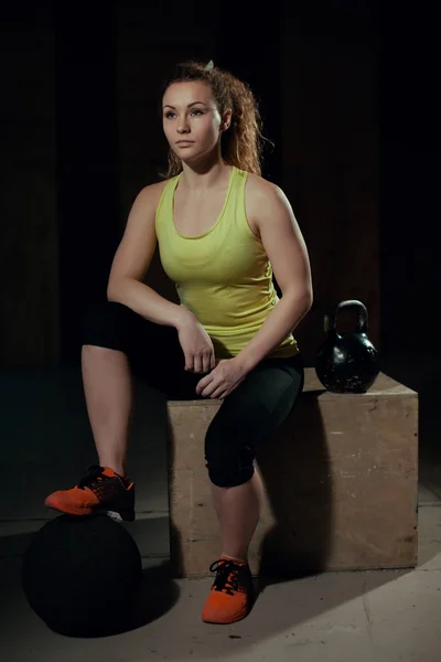 Mujer joven en el gimnasio con pesas y pelota . — Foto de Stock
