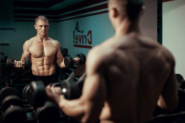 Egzersiz halter yapan genç vücut geliştirmeci erkek