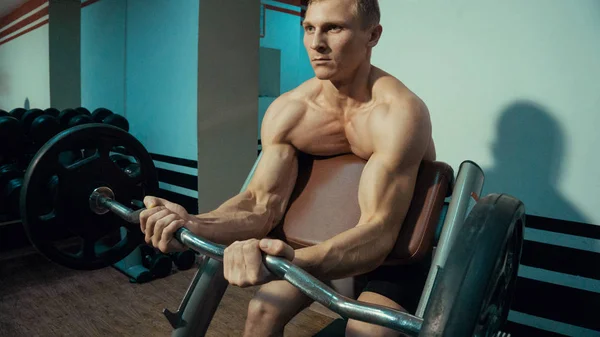 Ciąg człowiek ćwiczeń na biceps w siłowni — Zdjęcie stockowe