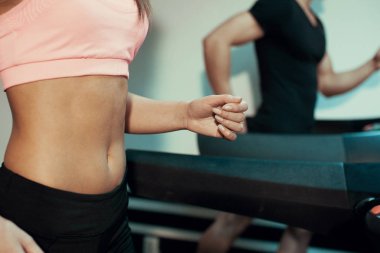 Spor salonunda bir koşu bandı üzerinde çalışan erkek ve kadın kapatmak