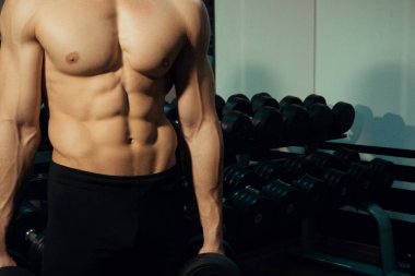 Dumbbells ile yakışıklı vücut geliştirmeci