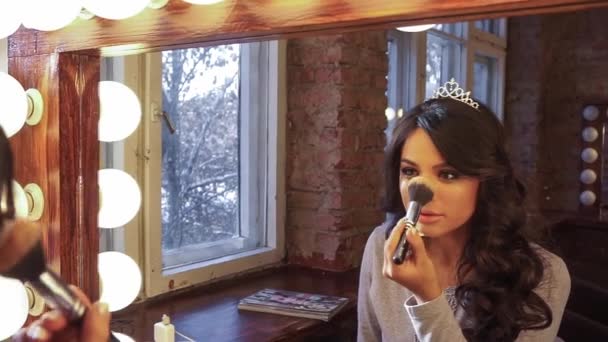 Beautiful brunette gets powder on the face in the mirror — Stock Video