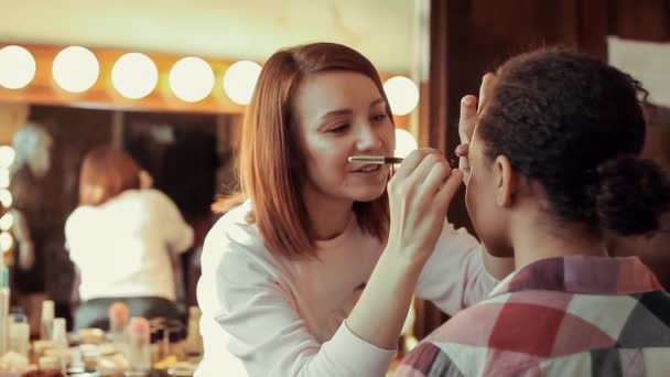 Wizażystka robi make up dla młody piękny model Afryki. — Wideo stockowe