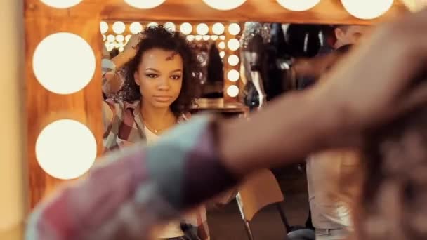 Красивая молодая девушка перед зеркалом в салоне красоты . — стоковое видео