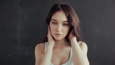 Beyaz t-shirt siyah arka plan üzerine kamera önünde poz içinde güzel genç kız