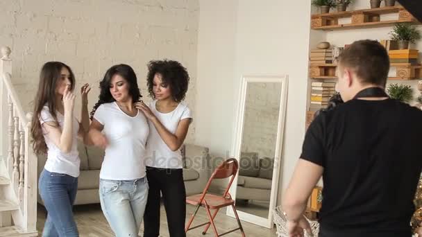 Chicas con camisa blanca posando delante de un fotógrafo. tras bastidores — Vídeos de Stock