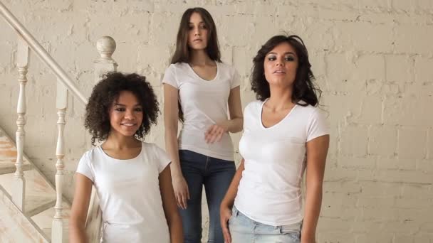 Tres hermosas chicas con camisa blanca posando en una sesión de fotos. Entre bastidores . — Vídeos de Stock