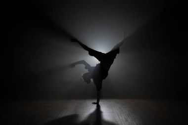 Arkadan aydınlatmalı poz hip-hop dansçısı.