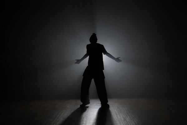 Dancer posing in the dark and smoke