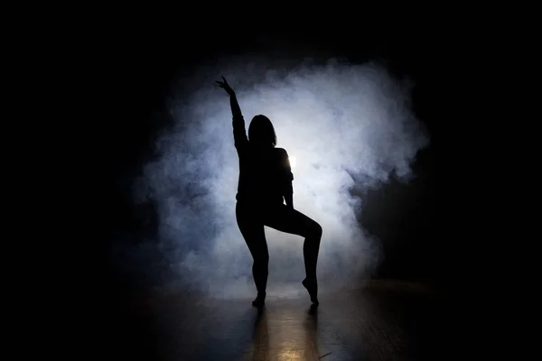 Bailarina posando en la oscuridad y el humo — Foto de Stock