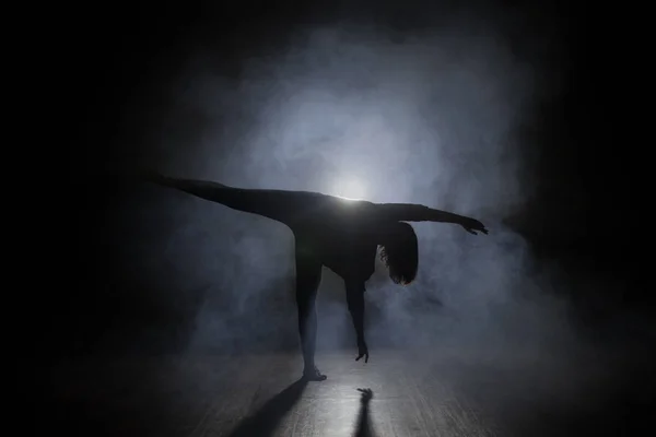 Hombre bailarín posando en la oscuridad y el humo — Foto de Stock