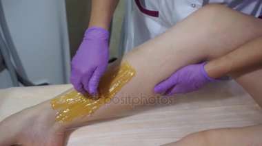 Spa salonda bacaklarda sıvı şeker şeker epilasyon. Şeker epilasyon ayak portre üzerinde.