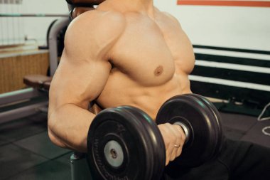 Spor salonunda pazı sallanan bir basın ile Bodybuilder