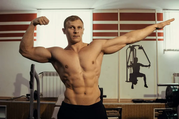 Svalnatý sportovec, kulturista s nahý trup lodě v tělocvičně. Kalený svaly, bicepsy — Stock fotografie