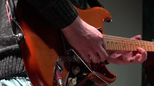 De man is magistraal een elektrische gitaar spelen op een rockconcert. Close-up. In slow motion. — Stockvideo
