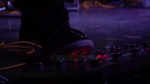 Музикант штовхає ногу на звуковий підсилювач для гітари — стокове відео