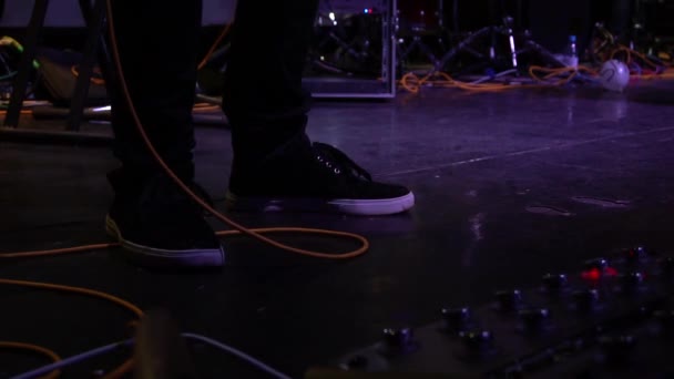Музикант штовхає ногу на звуковий підсилювач для гітари — стокове відео