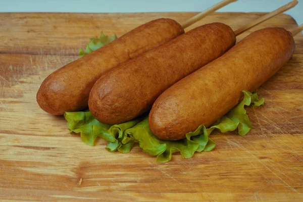 Comida tradicional americana perros de maíz en una hoja de lechuga. comida rápida . — Foto de Stock