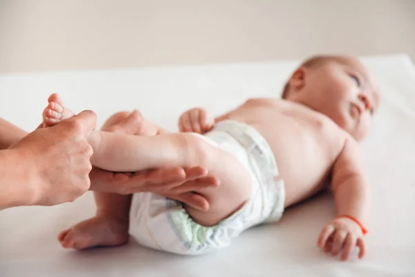 Il medico massaggia la gamba di un bambino su uno sfondo bianco. Massaggio bambino — Foto Stock