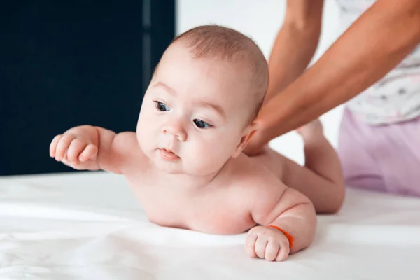 Kadın doktor beyaz arka plan üzerinde bebek masaj yapıyor — Stok fotoğraf