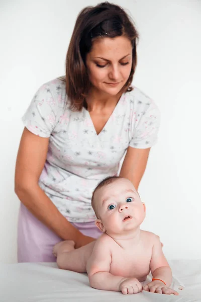 Жінка-лікар робить масаж спини дитині. Дитячий масаж . — стокове фото