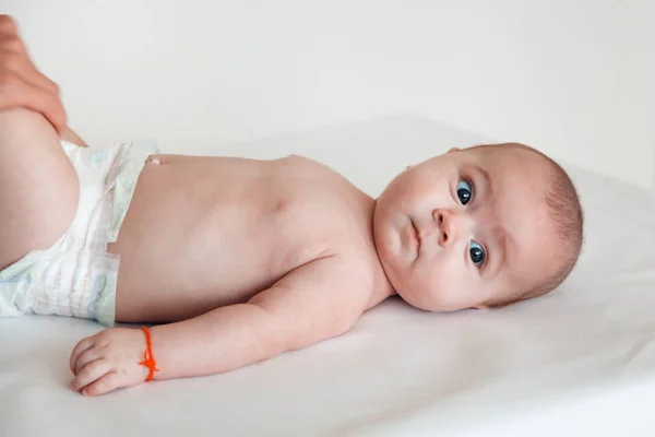 El médico masajea la pierna de un niño sobre un fondo blanco. Masaje bebé —  Fotos de Stock