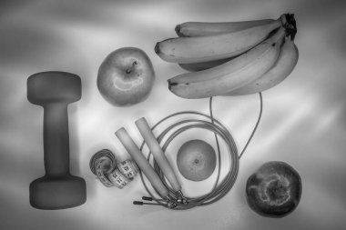 sağlıklı beslenme kavramı. Halter, ip, muz, portakal, ölçme bant bel, portakal, Kırmızı elma, yeşil elma, beyaz bir tablo. sağlıklı bir yaşam tarzı. spor. Fitness diyet. Siyah ve beyaz kavramı.