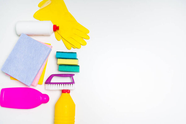 Range of cleaning products for the kitchen and bath. Detergents, chemical bottles, cleaning sponges and gloves. On a wooden table. view from above.