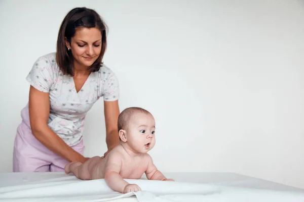 Žena doktor dělá baby masáž na bílém pozadí — Stock fotografie