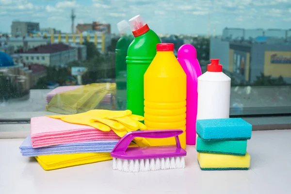 Range of cleaning products for the home. Detergents, chemical bottles, cleaning sponges and gloves. On the background of the window. — Stock Photo, Image