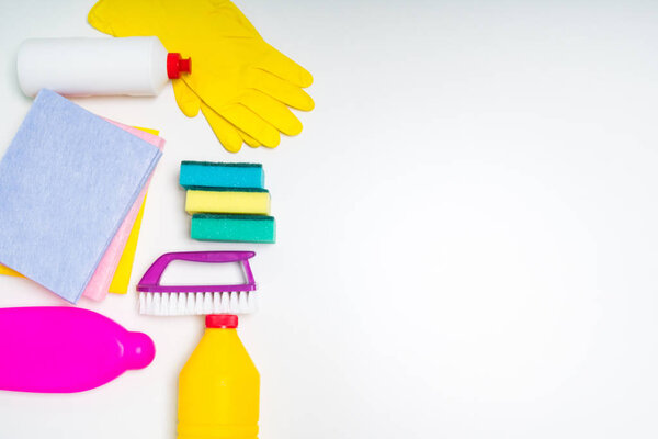 Range of cleaning products for the kitchen and bath. Detergents, chemical bottles, cleaning sponges and gloves. On a wooden table. view from above.