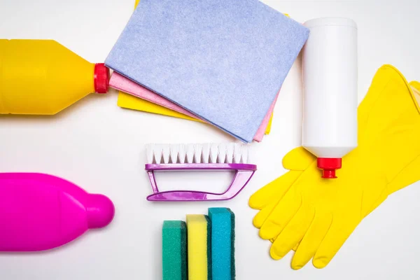 Range of cleaning products for the kitchen and bath. Detergents, chemical bottles, cleaning sponges and gloves. On a wooden table. view from above.