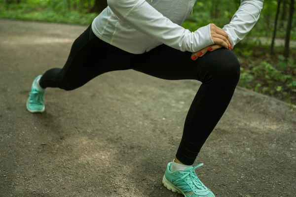 Giovane donna che fa stretching ed esercizio prima di fare jogging in un bellissimo parco — Foto Stock