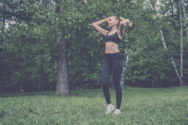 Siyah tayt ve başında bir parkta güzel kız saçını dokunur