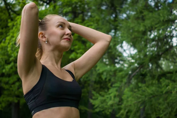 Bella ragazza nel parco in top nero tocca i capelli — Foto Stock