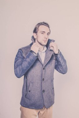 Bir kış ceket bir beyaz stüdyo arka plan üzerinde gösterilen şık genç adam. Stil. Güzellik. Moda. Sezon