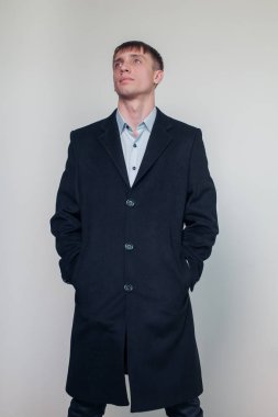 Siyah palto studio poz ciddi genç adam. Moda. Güzellik. Sezon.