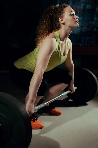 Mujer fuerte haciendo abdominales con una barra en el gimnasio —  Fotos de Stock