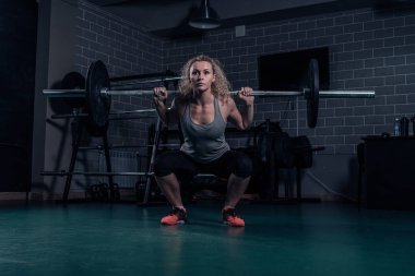 Güçlü kadın atlet ağır ağırlıklar ile ağız kavgası yapıyor. Çapraz Eğitim